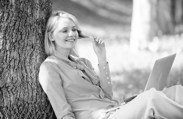 Girl work with laptop in park sit on grass. Education technology and internet concept. Natural environment office. Work outdoors benefits. Woman with laptop work outdoors lean tree. Minute for relax