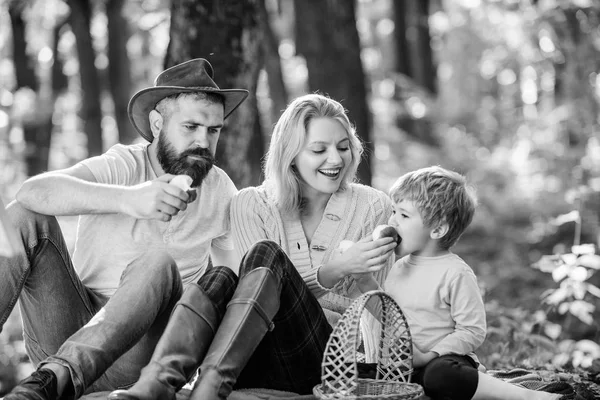 Conceito de dia de família. Família feliz com garoto relaxando enquanto caminhava na floresta. Fim de semana familiar. Mãe pai e filho pequeno sentar piquenique floresta. Unidos à natureza. Bom dia para piquenique de primavera na natureza — Fotografia de Stock