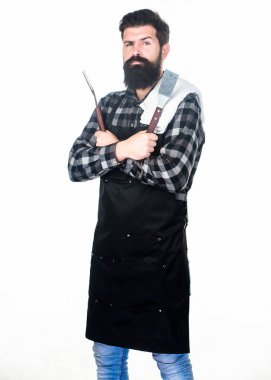 Barbekü aksesuarları. Sakallı adam ızgara tutucu aletleri tutuyor. Barbekü ızgara için metal eşyaları ile apron içinde hipster. Mangal aşçımız. Barbekü yemek. Barbekü seti kullanarak ızgarada yiyecek hazırlama