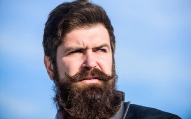 Her sakal tamamen benzersizdir. Şık bir görünüme yatırım yapın. Kalın sakal hızlı büyür. Erkek sakallı hipster resmi takım elbise mavi gökyüzü arka plan giymek. Yüz saç sakal ve bıyık bakımı. Sakal moda trendi