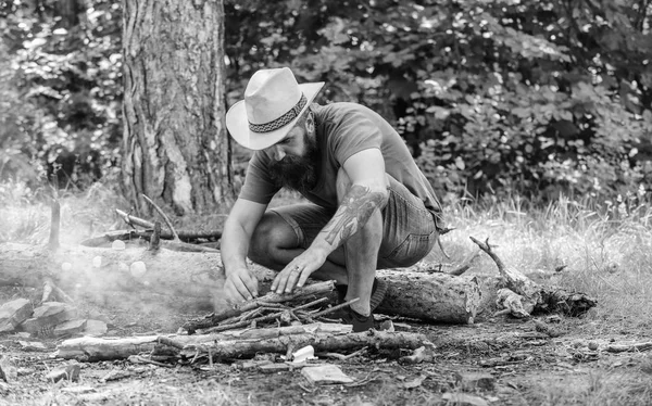 Ordna den skogen kvistar eller trä pinnar stående som en pyramid och placera bladen under. Hur man bygger brasa utomhus. Man halm hat förbereder brasa i skogen. Ultimate guide till eldar — Stockfoto