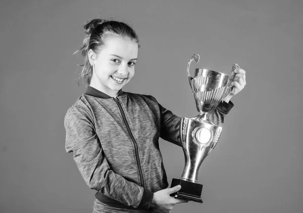 Sport achievement. Celebrate victory. Girl hold golden goblet. Importance of capturing evidence of kids progress. Proud of her achievement. Celebrating childrens achievements great and small