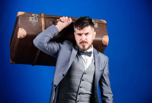 On the way to success. businessman in bow tie. bearded man in formal suit. heavy bag. mature traveller. stylish esthete with vintage bag. business trip with retro suitcase. Enjoying the trip