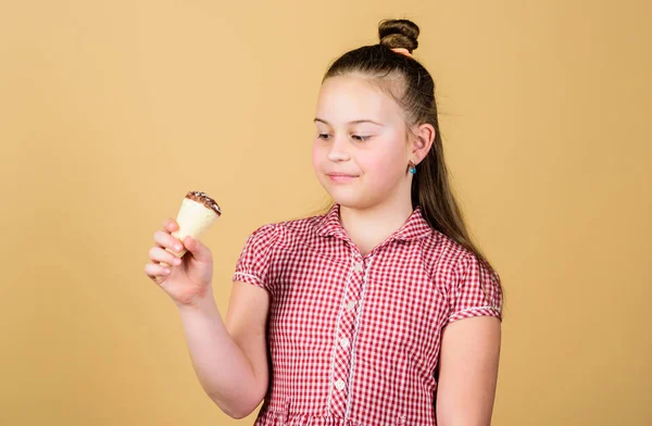 International childrens day. Sweet tooth concept. Girl little child eat ice cream cone beige background. Summer is here. Delicious ice cream. Happy childhood. Carefree kid enjoy sweet ice cream