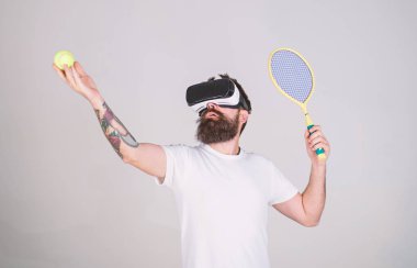 Sanal gerçeklik kulaklık tenis oynuyor, yakışıklı adam arka plan gri. Yenilikçi spor oyunları için modern teknolojisini kullanıyor. Vr gözlüklü play tenis raket ve top ile. Sanal Tenis kavramı