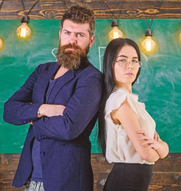 Sakal ve gözlük stand sırt sırta, kara tahta arka plan öğretmen olan adam. Bayan ve birlikte okulda çalışan hippi. Öğretmen ve öğretmen rahat görünüyor. Okul personeli kavramı