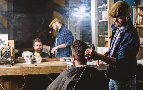 Reflexion Fryzjer układania włosów Brodaty klienta z grzebienia. Hipster klienta coraz fryzurę. Koncepcja fryzjera. Człowiek z broda i wąsy w Fryzjer krześle przed lustrem tło — Zdjęcie stockowe