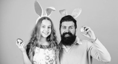 Yumurta için arıyorum. Baba ve kızı Paskalya bunny kulaklarına gülümseyen aile. Mutlu bir aile. Aile Paskalya kutluyor. Mutlu baba ve çocuk renkli Paskalya yumurtaları ile. Ailesi ne kadar da yıllık Paskalya yumurtası avı