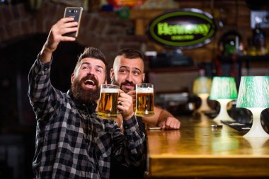 Barda bira içen adam. Çevrimiçi iletişim. İnsan sakallı hipster akıllı telefon tutun. Selfie kavramı almak. Pub büyük akşam hatırlamak selfie fotoğraf çekin. Arkadaşlarınızı sosyal ağlara selfie gönderin