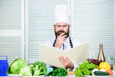 Nihai aşçılık rehberi adım adım. Kitap tarifleri boşluğu kopyalıyor. Şapkalı ve önlüklü adam kitap okudu. Yemek tarifleri kitabı konsepti. Yemek pişirme yeteneğini geliştir. Yemek pişirmek için faydalı bir kitap. Aşçılık kariyerine başla