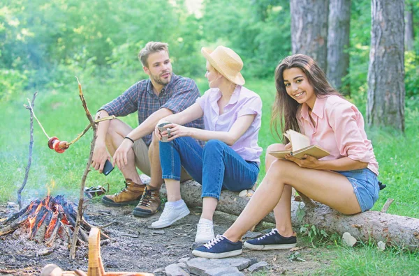 Company friends spend great time picnic or barbecue near bonfire. Idyllic weekend. Friends enjoy weekend barbecue in forest. Group friends spend leisure weekend hike picnic forest nature background