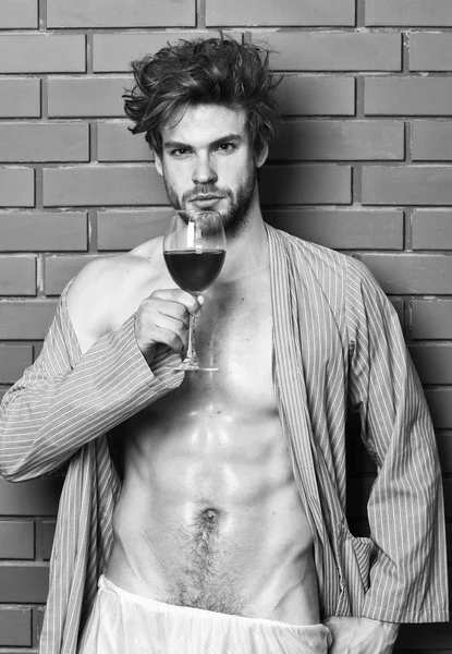 Drink wine and relax. Man sexy chest sweaty skin hold wineglass. Guy attractive relaxing with alcohol drink. Bachelor enjoy wine. Macho tousled hair degustate luxury wine. Erotic and desire concept