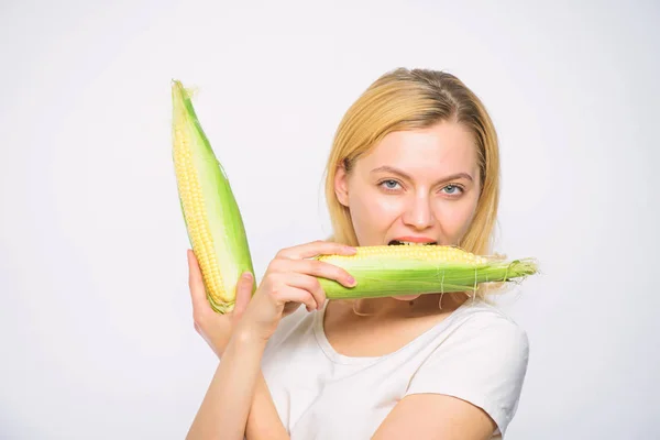 Alimento vegetariano y saludable producto orgánico natural. Concepto de cosecha de maíz. Concepto de nutrición vegetariana. Mujer mantenga mazorca de maíz amarillo sobre fondo blanco. Chica humor juguetón mantenga granos maduros en las manos —  Fotos de Stock