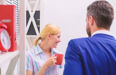 İki neşeli genç insanlar kahve fincanı holding ve Office dururken konuşuyor. İki sıradan insan. İş görüşmesi.