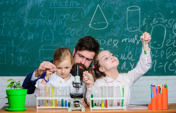 Jak studovat děti. Fascinující lekce biologie. Člověk vousatý učitel pracuje s mikroskopem a zkumavkami ve třídě biologie. Školní experiment. Vysvětlení biologie dětem — Stock fotografie