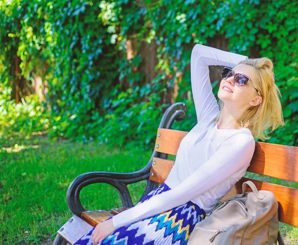 Леди нужно расслабиться и отдохнуть. Девушка сидеть скамейка отдыха в тени, зеленый фон природы. Отпуск мечты. Блондинка в солнечных очках мечтает об отпуске, отдыхает в парке — стоковое фото