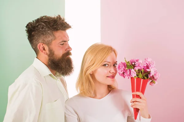 Woman enjoy fragrance bouquet flowers. Couple in love happy celebrate anniversary. Man with beard takes care about girlfriend happiness. Lady likes flower husband gifted her. Flowers delivery concept — Stock Photo, Image