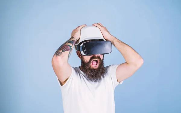 3D design concept. Man with beard in VR glasses shocked and disappointed, light blue background. Architect or engineer with virtual reality glasses. Guy in helmet works as engineer in virtual reality — Stock Photo, Image