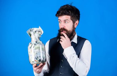 Genel tasarruf ipuçları. Adam sakallı hipster kavanoz dolu para. Nakit sorunları tutmak. Dolar tasarrufları olan bir işadamı. Zenginlik ve refah. Güvenlik ve nakit para tasarrufu. Bankacılık konsepti