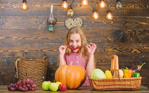 Farm themed games and activities for kids. Girl kid at farm market with fall harvest. Child little girl celebrate harvesting. Family farm festival concept. Kid farmer with harvest wooden background