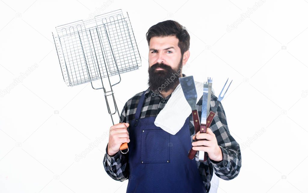 Barbecue party. Grill cook using portable barbecue cooking tools. Happy hipster holding stainless steel tools for preparing barbecue food. Bearded man with barbecue grid and utensils in hands