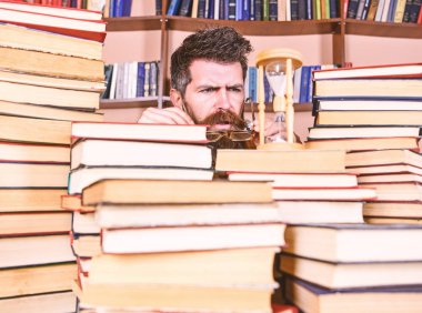 Zaman akışı kavramı. Dostum, bilim adamı bardaklarda kum saati görünüyor. Öğretmen ya da sakal Kitaplığı'nda eğitim ile öğrenci. Adam ciddi yüz izlerken zaman raflardan, arka planda gidiyor