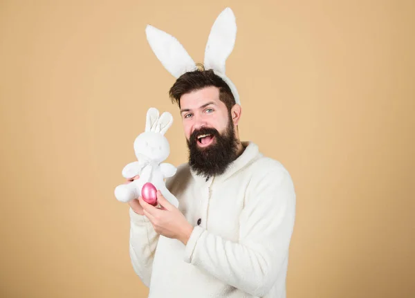 Coelho da Páscoa. Homem vestindo terno de coelho brincar com brinquedo. Engraçado homem coelhinho orelhas macias. Conceito de atividades de Páscoa. Ainda é infantil. Comemore a Páscoa. cara barbudo hipster alegre coelho com longo branco orelhas — Fotografia de Stock