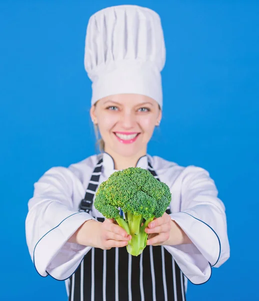 Diätkonzept. gesund ernähren. Mädchen tragen Hut und Schürze. gesunde Ration. Profi-Köchin halten rohes Brokkoli-Gemüse. kostenlose gesunde vegetarische und vegane Rezepte. gesunde Rohkost — Stockfoto