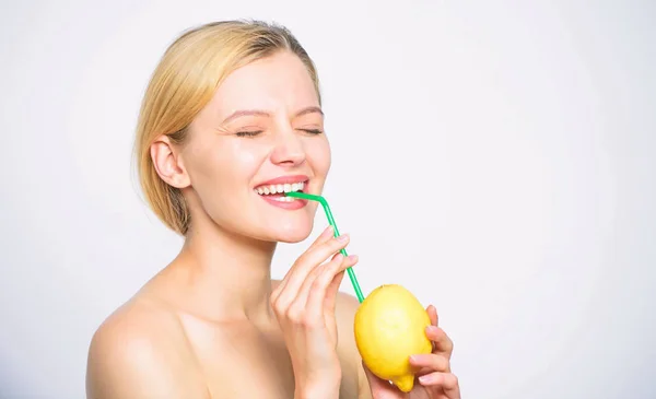 Egészséges életmód és táplálkozás szerves fogalom. A lány ital friss gyümölcslé egész citrom gyümölcs koktél szalma. Előnyei ivóvíz lemon vizet a reggel éhgyomorra. Nő élvezni ital vitamin — Stock Fotó