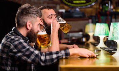 Hipster acımasız adam Bar tezgahında arkadaşıyla bira içiyor. Erkekler sarhoş rahatlatıcı eğleniyor. Alkol içkileri. Bira ile pub rahatlatıcı arkadaşlar. Serinletici bira konsepti. Erkekler birlikte bira içiyor