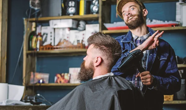 Hippi saç modeli almak istemci sakallı. Saç kurutma makinesi styling saç istemci ile neşeli yüzündeki berber. Kuaför saç kurutma makinesi ile saç modeli sakallı adam, salon arka plan için çalışır. Tasarım konsepti