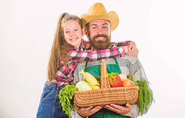 Family farm organic vegetables. Farmers family homegrown harvest. Gardening and harvesting. Father farmer or gardener with daughter hold basket harvest vegetables. Man bearded rustic farmer with kid