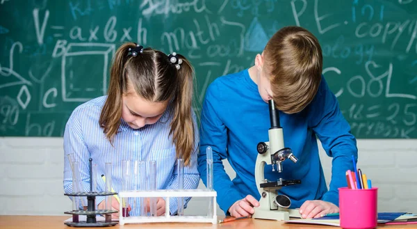 Los niños estudian química. Lección de química escolar. Laboratorio escolar. Educación escolar. Chica y niño se comunican mientras realizan el experimento escolar. Niños estudiando juntos en el aula. Análisis químico — Foto de Stock