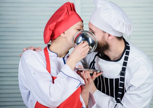 man and woman chef in restaurant behind metallic tray. secret ingredient by recipe. cook uniform. Family cooking in kitchen. couple in love with perfect food. Menu planning. culinary cuisine