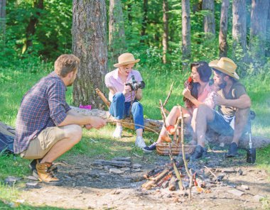 Turistler yürüyüşçü bekleyen piknik Aperatif rahatlatıcı oturum oturmak. Şirket zammı piknik doğa arka plan sahip. Ormandaki şenlik ateşi yakın arkadaşlarıyla piknik. Yürüyüşçüler yemek vakti sırasında rahatlatıcı. Yaz pikniği