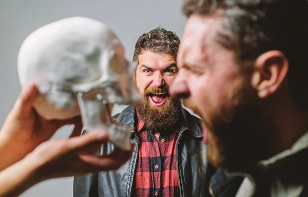 Human fears and courage. Looking deep into eyes of your fear. Man brutal bearded hipster looking at skull symbol of death. Overcome your fears. Be brave. Focused on breaking fear. Psychology concept