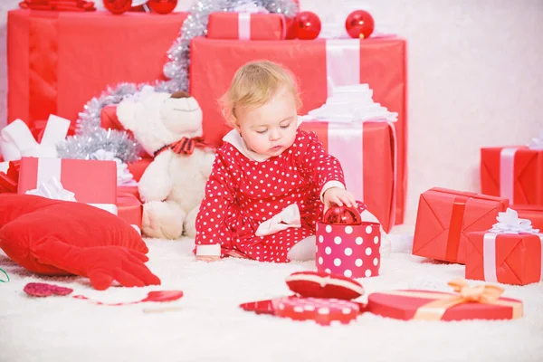 Bambina giocare vicino mucchio di scatole regalo. Vacanza in famiglia. Regali per il primo Natale del bambino. Attività natalizie per i più piccoli. Concetto di miracolo di Natale. Cose da fare con i bambini a Natale — Foto Stock