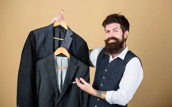 En helt ny garderob. Garderob konsult rekommendera formella stil rockar. Hipster väljer kostym jacka på garderob varuhus. Bearded man med klädkollektion på mens garderob — Stockfoto