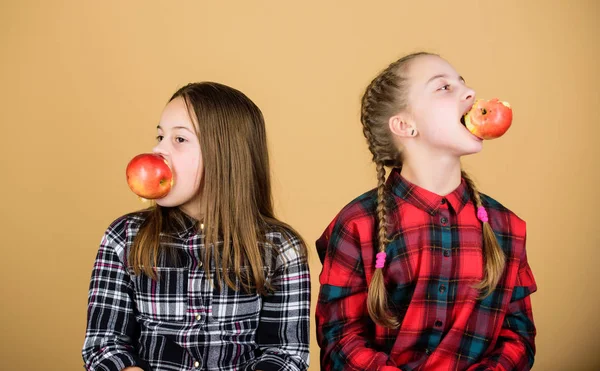 Φρούτα, φρούτα και περισσότερα φρούτα. Μικρά κορίτσια που τρώνε φρέσκα φρούτα. Μικρά κορίτσια που κρατάνε μήλα στο στόμα. Τα χαριτωμένα παιδιά απολαμβάνουν υγιεινό σνακ. Αξιολάτρευτο αδελφές που έχουν φυσικό βιολογικό σνακ — Φωτογραφία Αρχείου