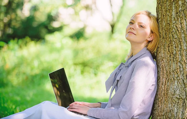 Natural environment office. Work outdoors benefits. Woman with laptop work outdoors lean tree. Minute for relax. Girl work with laptop in park sit on grass. Education technology and internet concept — Stock Photo, Image