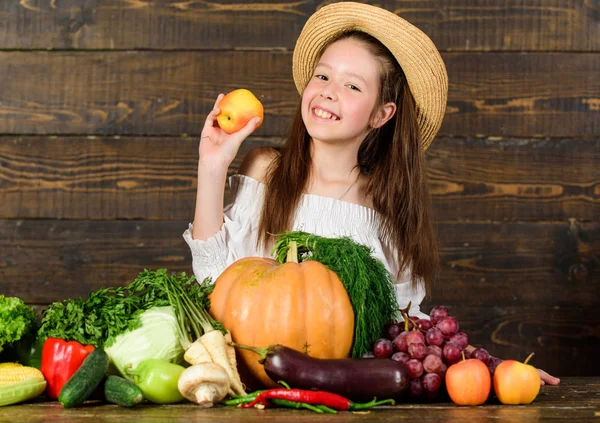 Farm activities for kids. Girl kid farm market with fall harvest. Child celebrate harvesting. Kid farmer with harvest wooden background. Family farm festival concept. Traditional autumnal fest