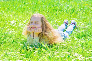 Grassplot, yeşil arka plan çimlere yatan kız. Çocuk çayır yalancı bahar güneşli hava keyfini çıkarın. Barış ve huzurlu kavramı. Yüz gülümseyerek kıza harcamak açık havada eğlence