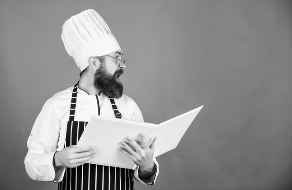 Book recipes. According to recipe. Man bearded chef cooking food. Culinary arts concept. Amateur cook read book recipes. Man learn recipe. Try something new. Cookery on my mind. Improve cooking skill — Stock Photo, Image