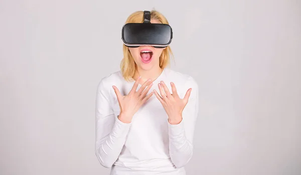 Aufgeregt lächelnde Geschäftsfrau mit Virtual-Reality-Brille. Frau mit Virtual-Reality-Brille vor grauem Hintergrund. Lustige junge Frau mit VR. Virtuelle Realität. — Stockfoto
