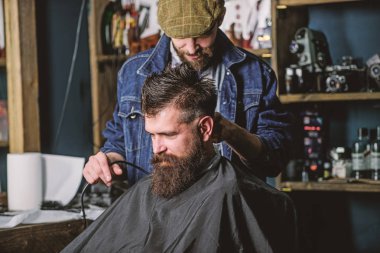 Kuaför saç kesme makinesi ile sakallı adam berber arka plan saç kesimi üzerinde çalışır. Hippi saç modeli kavramı. İstemci ense üzerinde kırpma makası kesme saçlı berber. Hipster istemci Başlarken saç kesimi