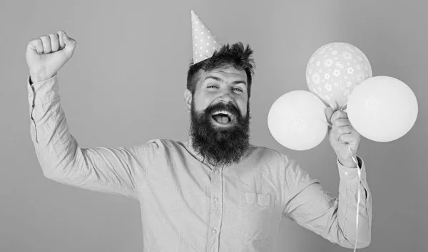 Homem com barba na moda comemorando aniversário. Papai cumprimentando crianças no occation especial, dia internacional das crianças. Homem barbudo pulando com balões brilhantes, de volta à infância, conceito de felicidade — Fotografia de Stock