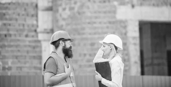 Construction site safety inspection. Discuss progress project. Construction project inspecting. Safety inspector concept. Woman inspector and bearded brutal builder discuss construction progress — Stock Photo, Image