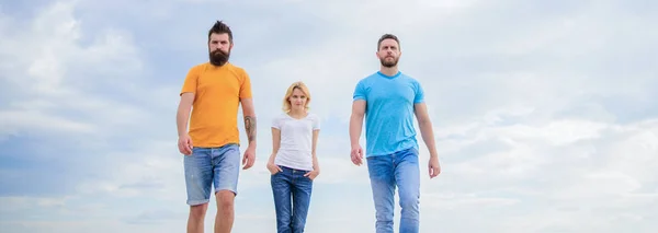 Simple décontracté doit avoir. Groupe de personnes en tenue décontractée. Jolie femme et amis hommes marchant en plein air. Jeunes gens dans un style décontracté sur ciel nuageux. Les gens de la mode ont l'air décontractés en tenue d'été — Photo