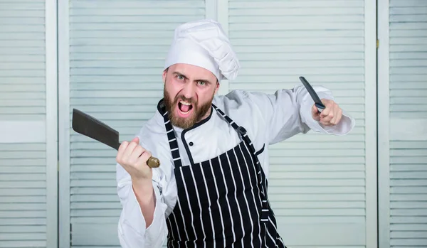 He is a champion in the kitchen. angry bearded man with knife. love food. cook in restaurant. chef ready for cooking. confident man in apron and hat. Professional in kitchen. culinary cuisine