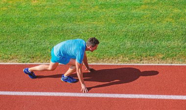 İpuçları yeni başlayanlar için çalışıyor. Adam atlet standı düşük başlangıç pozisyonu stadyum yolu. Runner gitmeye hazır. Eklem hareketliliğini egzersizleri esneklik ve fonksiyon geliştirmek için. Sporcu atlet yarış hazırlanın